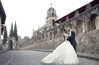 bride and groom standing on gray concrete bridge during daytime