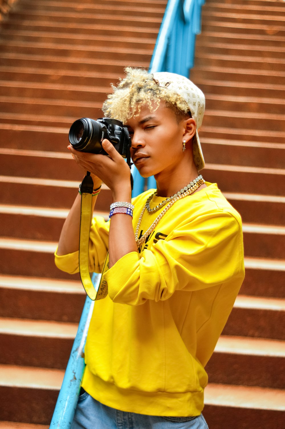 woman in yellow button up shirt holding black dslr camera