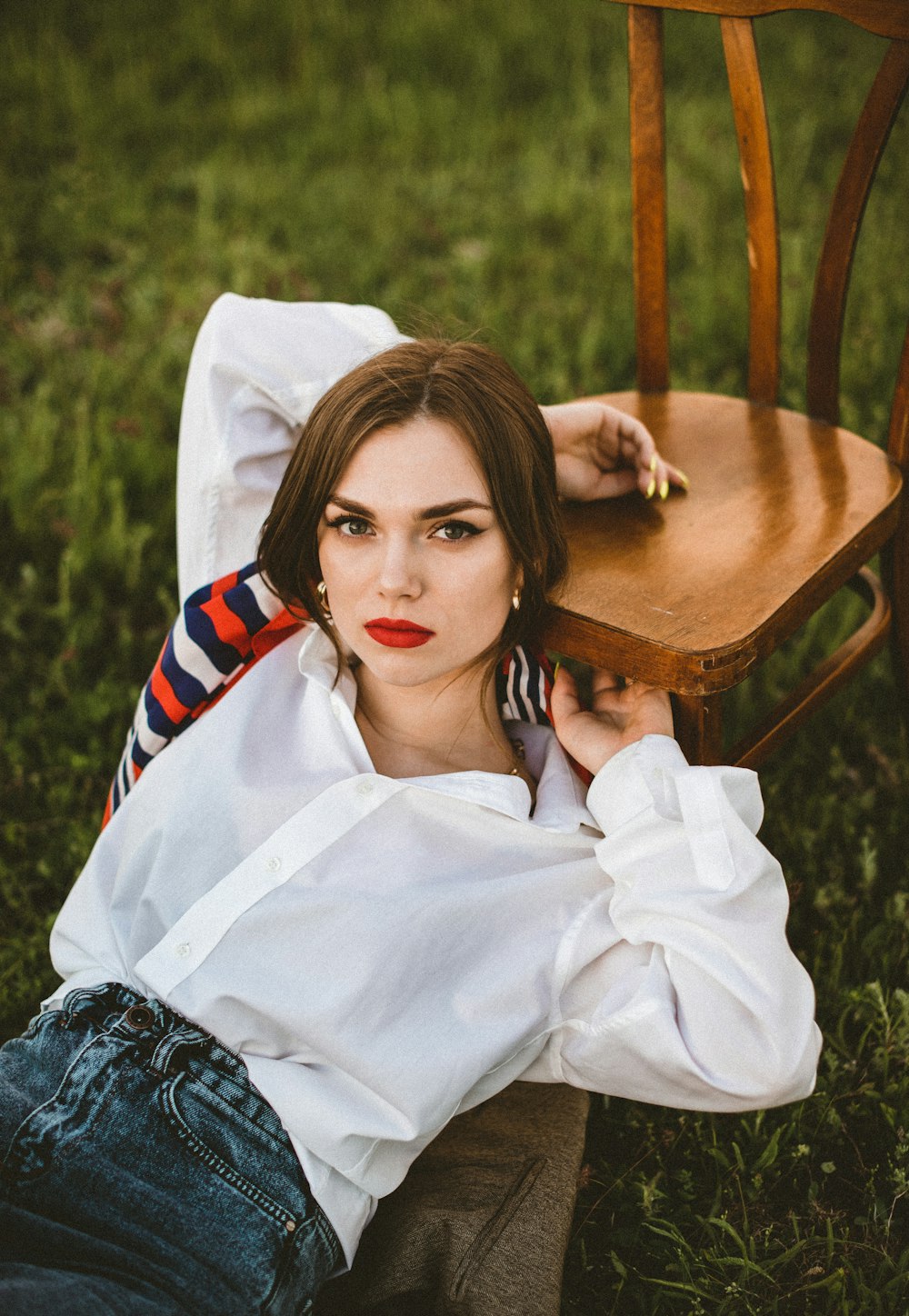 woman in white long sleeve shirt sitting on brown wooden chair