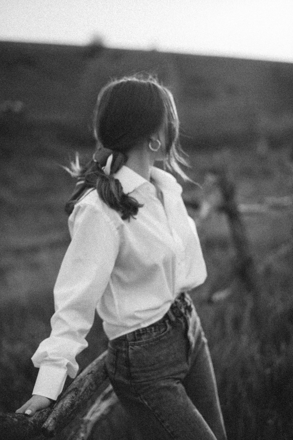 grayscale photo of girl in white dress shirt and blue denim jeans