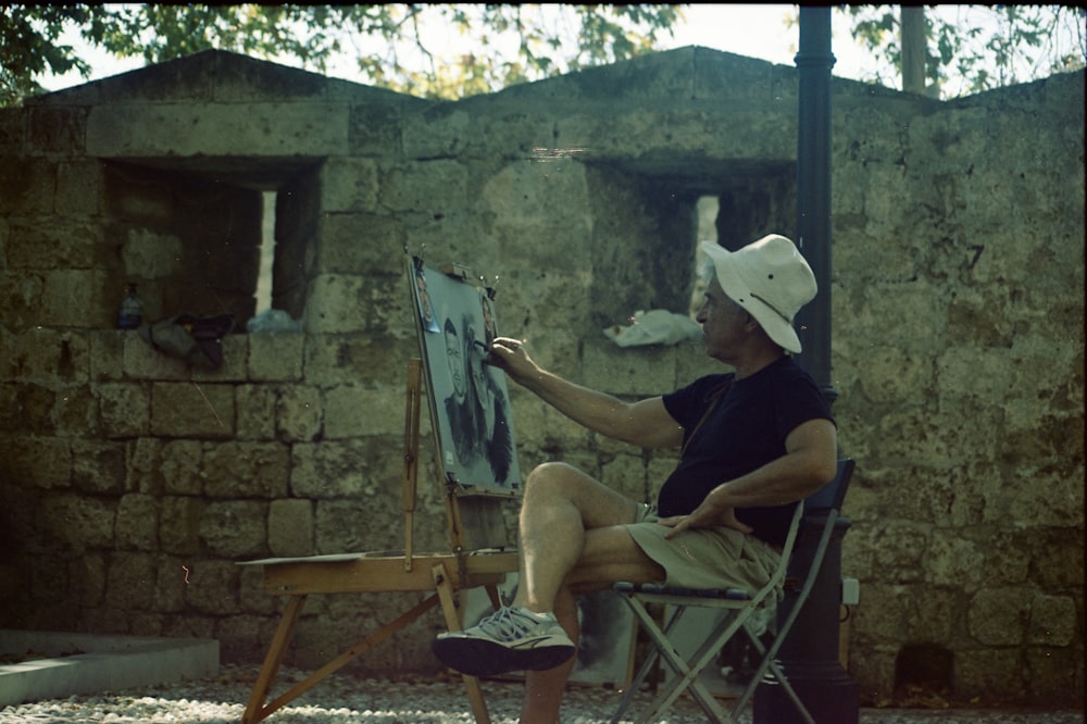 man in black shirt sitting on white folding chair