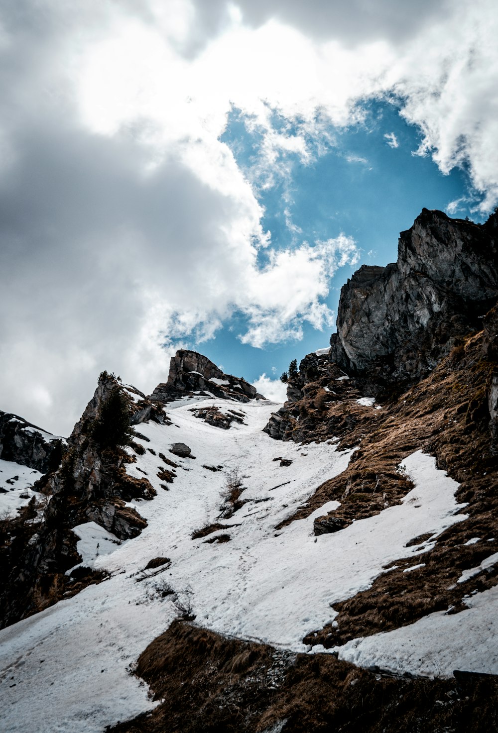 montagna coperta di neve sotto cielo blu e nuvole bianche durante il giorno