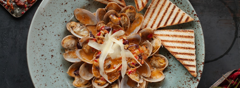 brown and white sliced food on white ceramic plate