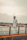 man in white button up shirt standing beside brown wooden fence during daytime