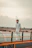 man in white button up shirt standing beside brown wooden fence during daytime