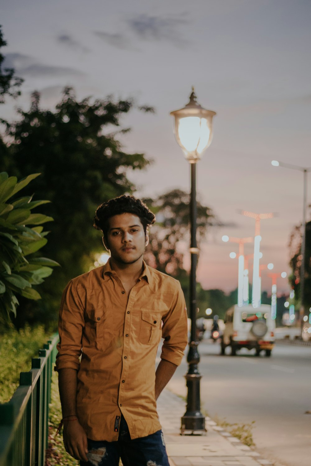 man in brown dress shirt standing near green plant during daytime