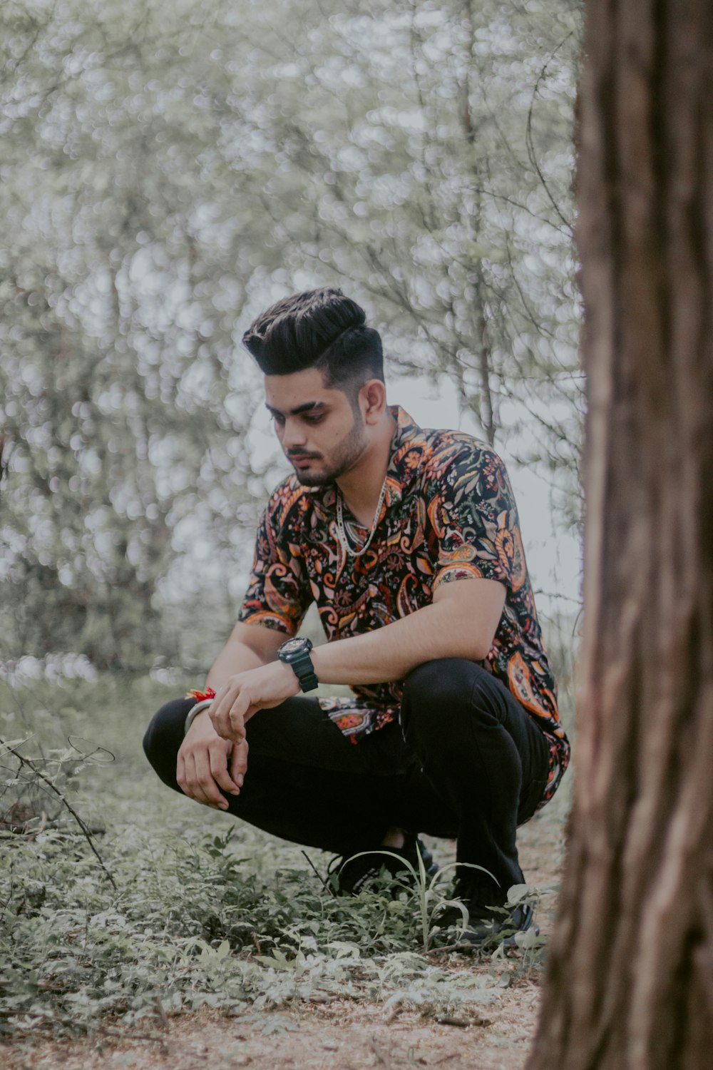 man in brown and white button up shirt and black pants sitting on brown tree log