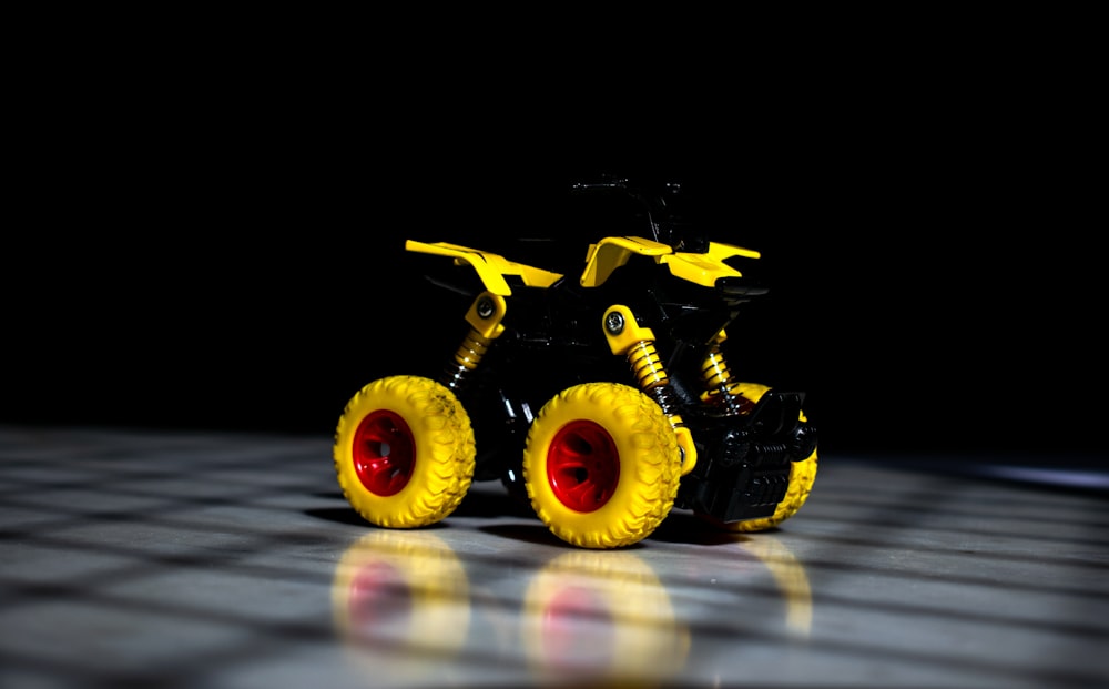 a yellow toy truck sitting on top of a checkered floor