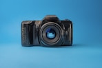 black nikon dslr camera on blue surface