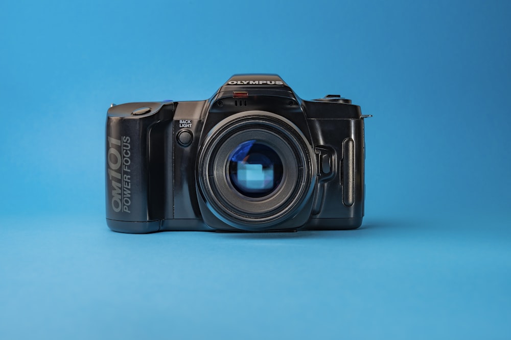 Cámara réflex digital Nikon negra sobre superficie azul