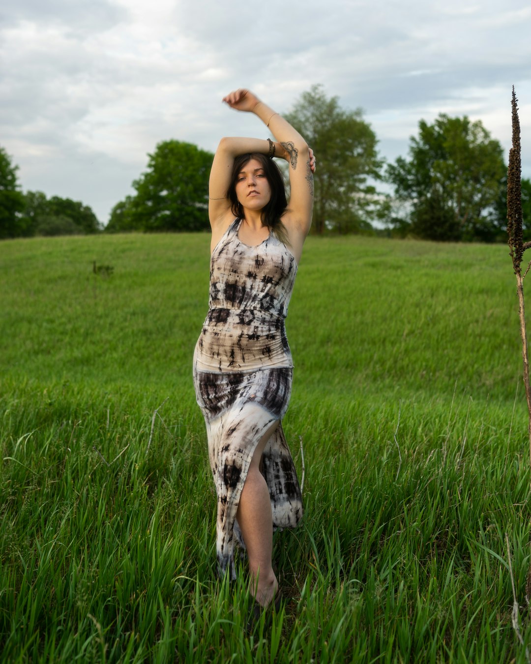 woman in white and black sleeveless dress standing on green grass field during daytime