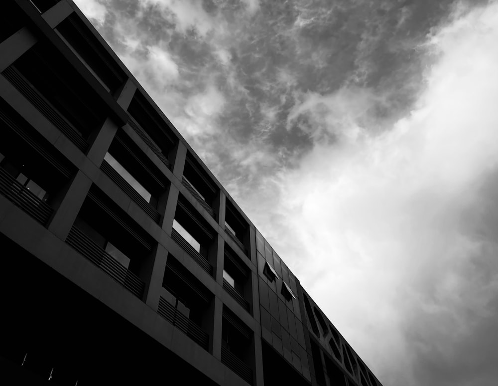 grayscale photo of concrete building under cloudy sky