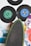 A collection of vintage vinyl records with colorful labels is arranged alongside a skateboard. The records include labels such as Columbia and Chrysalis, showcasing various designs with colors like green and blue. The skateboard, with a black grip and green edges, is positioned diagonally, adding to the retro aesthetic.