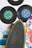 A collection of vintage vinyl records with colorful labels is arranged alongside a skateboard. The records include labels such as Columbia and Chrysalis, showcasing various designs with colors like green and blue. The skateboard, with a black grip and green edges, is positioned diagonally, adding to the retro aesthetic.