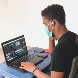 A translator working on documents with a headset and laptop.
