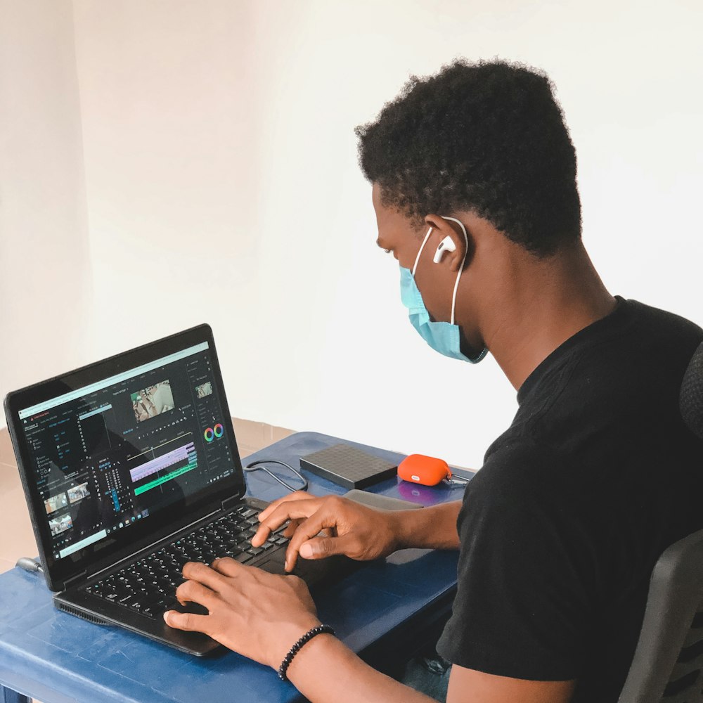 man in black crew neck t-shirt using black laptop computer