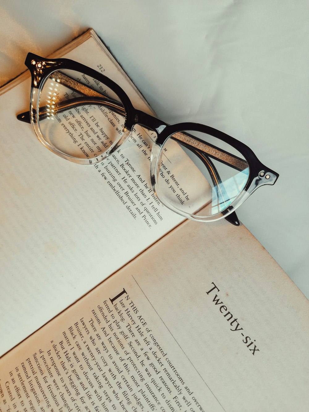 brown framed eyeglasses on white printer paper