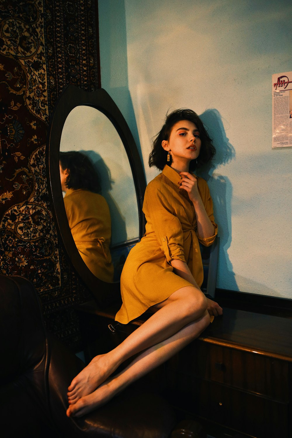 woman in yellow long sleeve shirt sitting on brown wooden chair