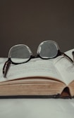 An open law book with a pair of glasses resting on it.