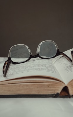 An open law book with a pair of glasses resting on it.