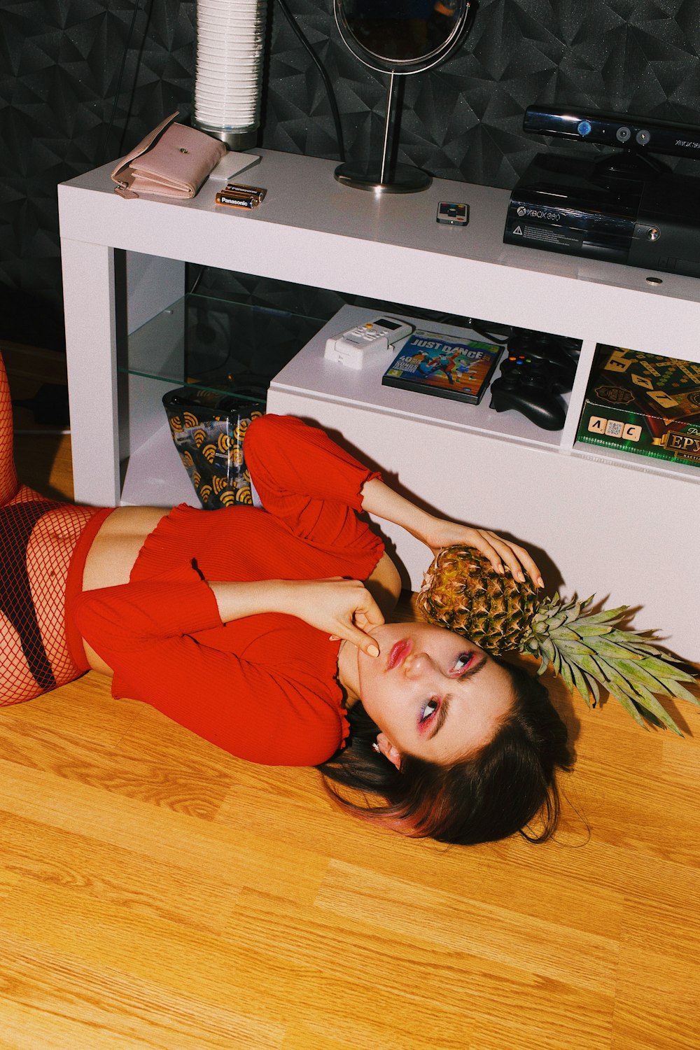 woman in red long sleeve shirt holding pineapple fruit