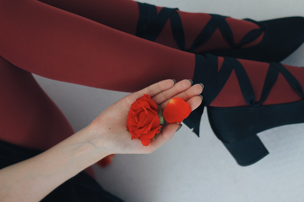 person holding red and black textile