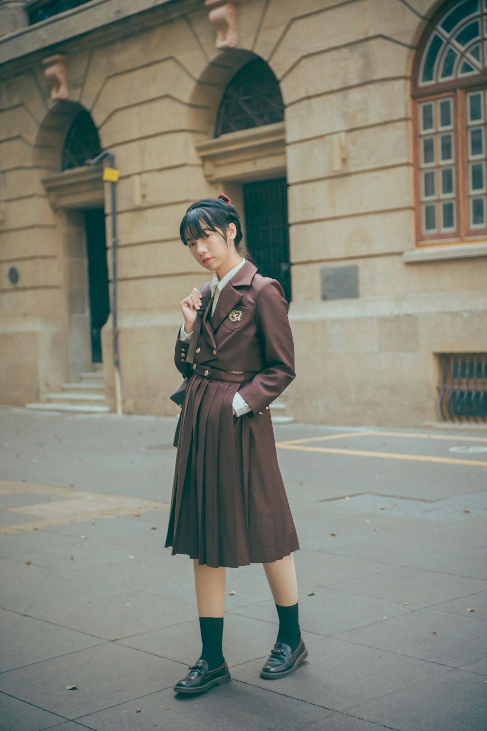 woman in black long sleeve dress standing on sidewalk during daytime