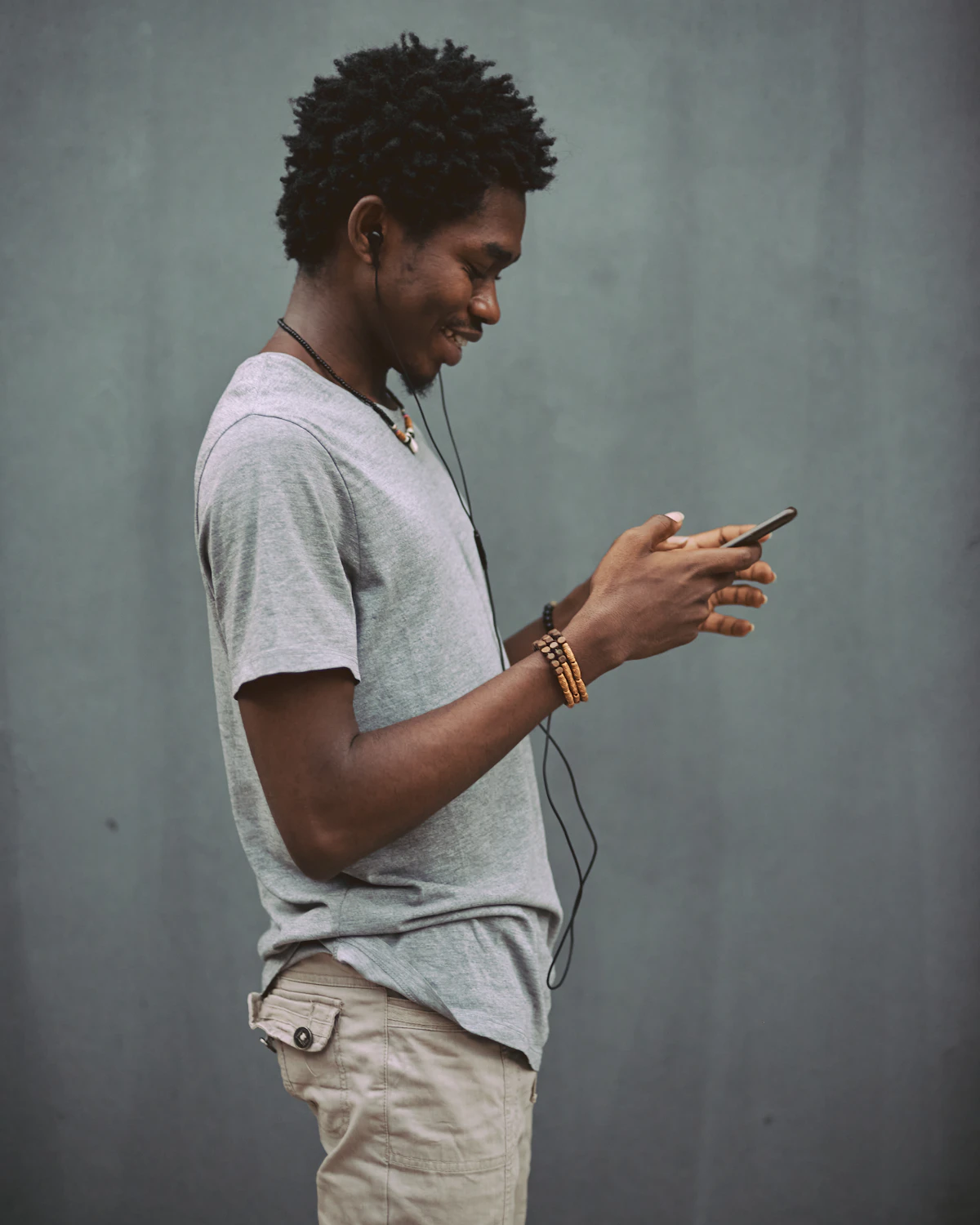 Man in white crew neck t-shirt holding smartphone