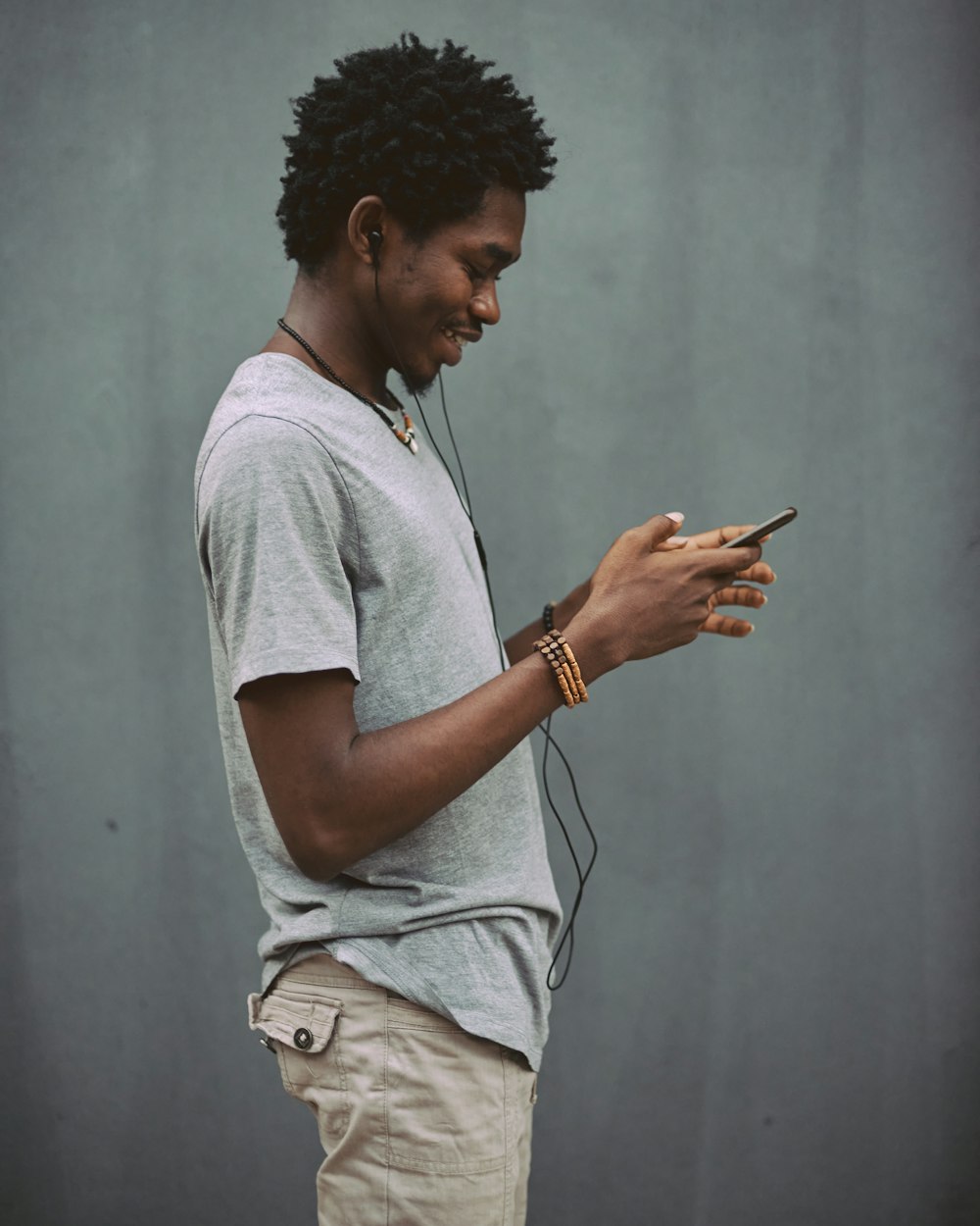 man in white crew neck t-shirt holding smartphone