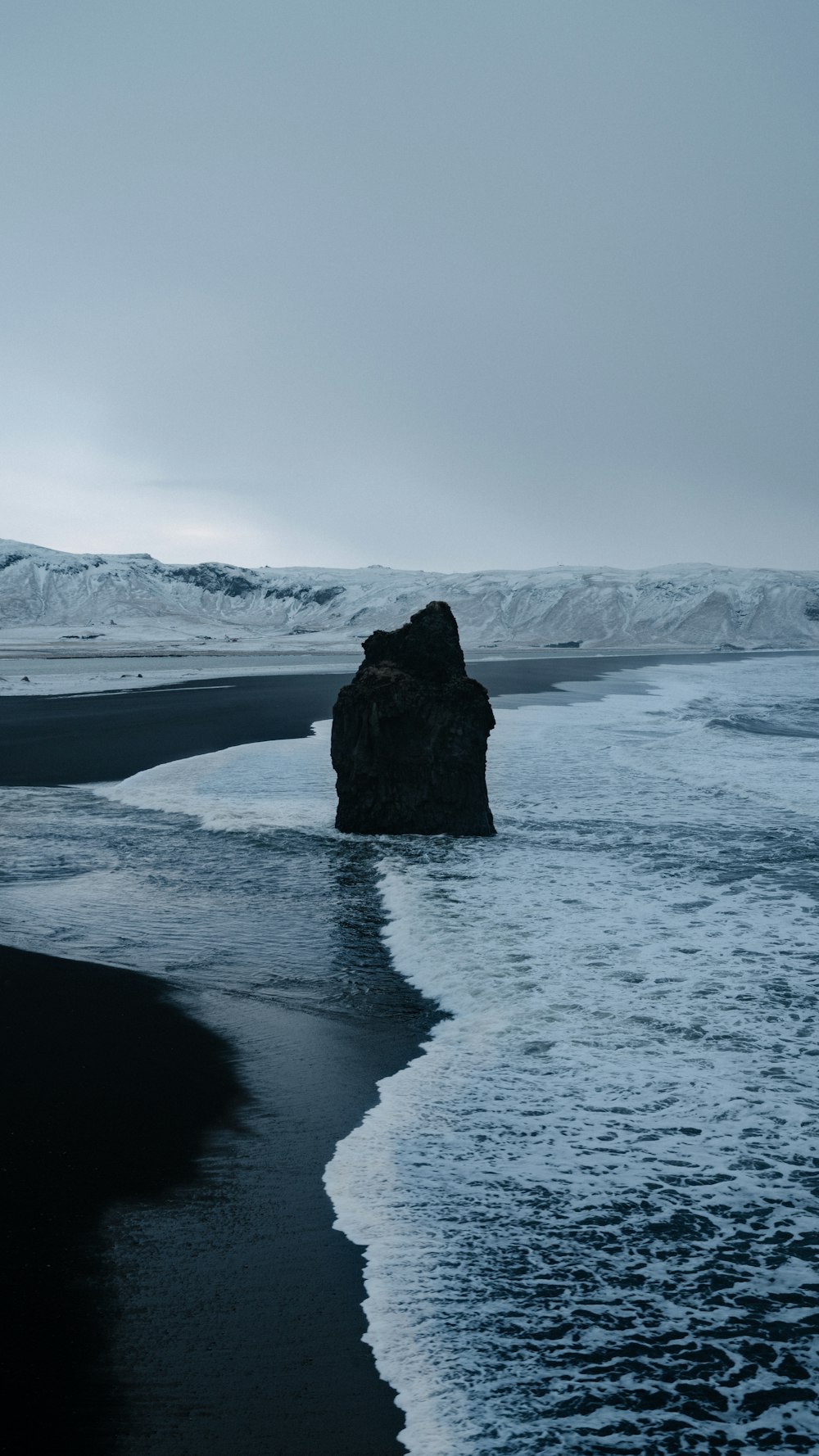 black rock formation on snow covered ground during daytime