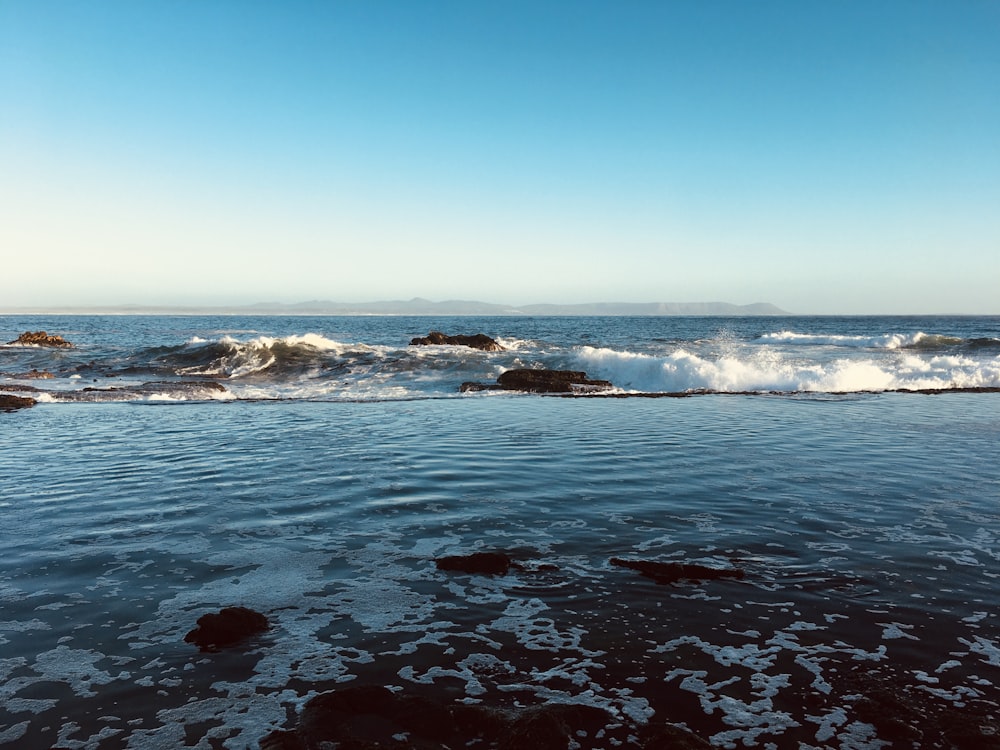 ocean waves crashing on shore during daytime