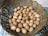 Close-up of a rustic basket filled with assorted colorful eggs on a wooden table.