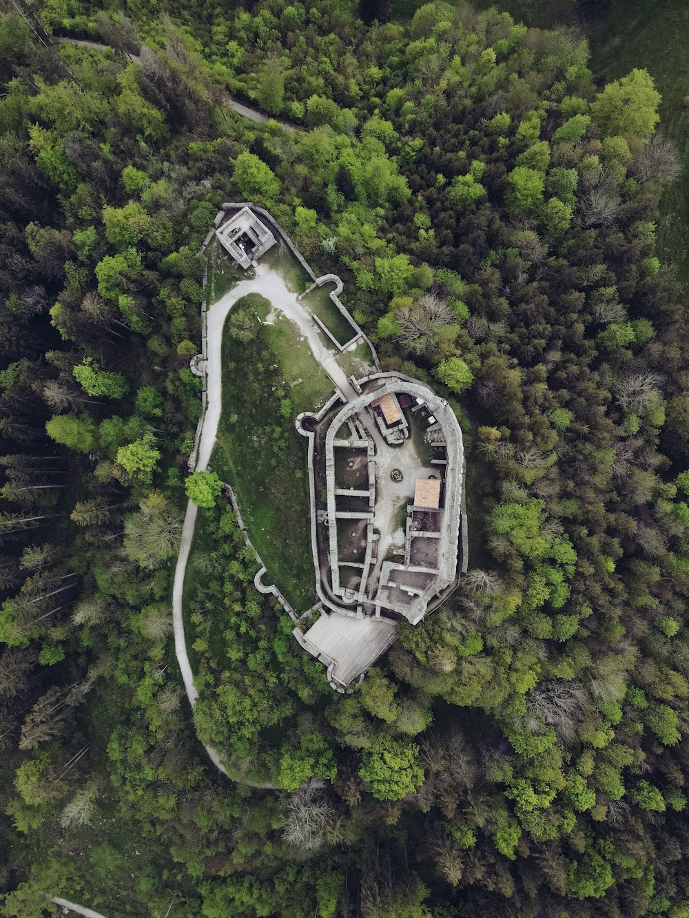 aerial view of white and gray building on green forest during daytime