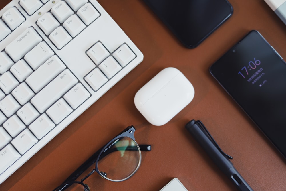 black framed eyeglasses beside apple magic mouse and apple keyboard