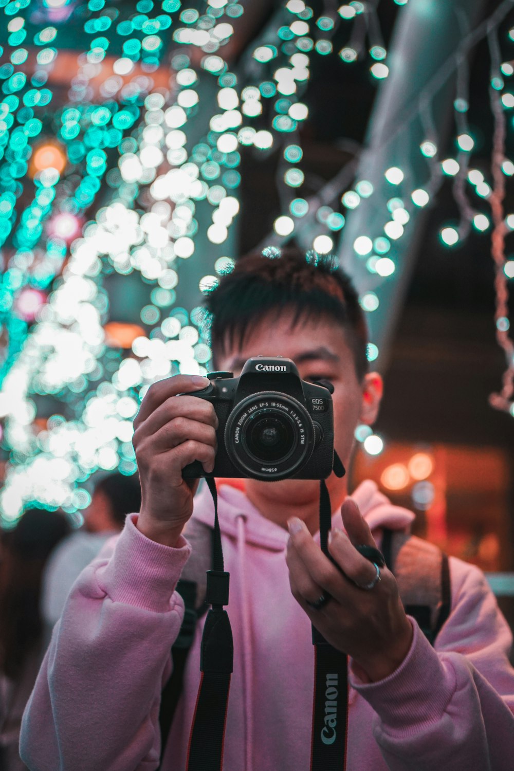 woman in pink jacket holding black nikon dslr camera