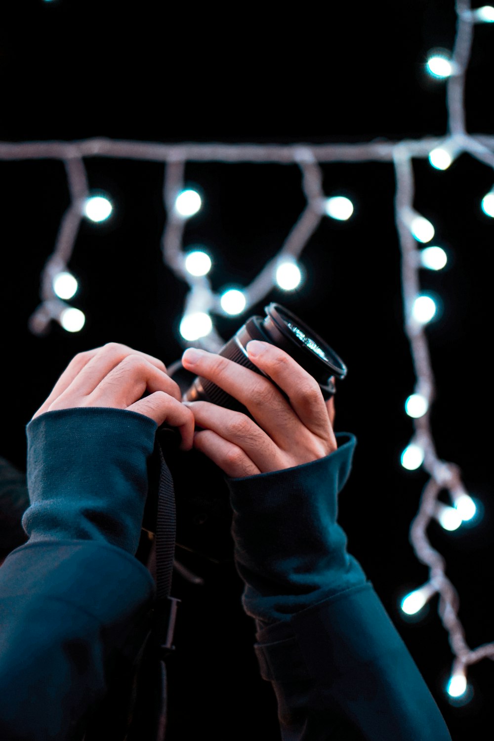 person in blue jacket holding black smartphone