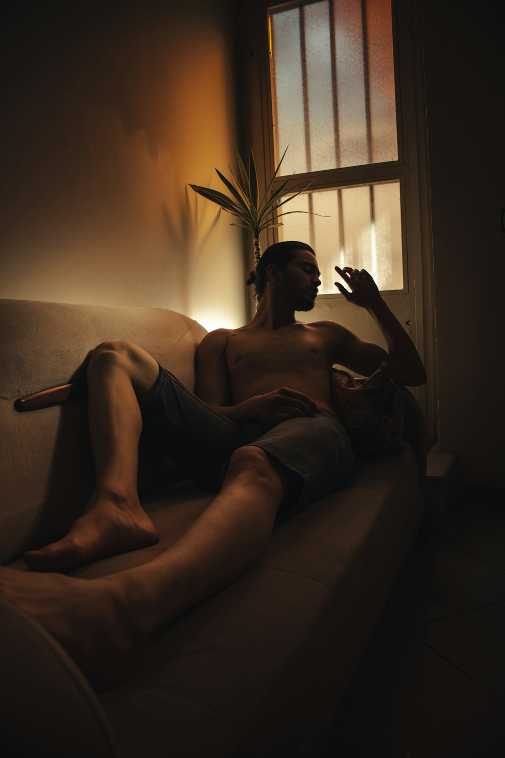 topless man lying on couch