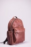 brown leather backpack on white wall