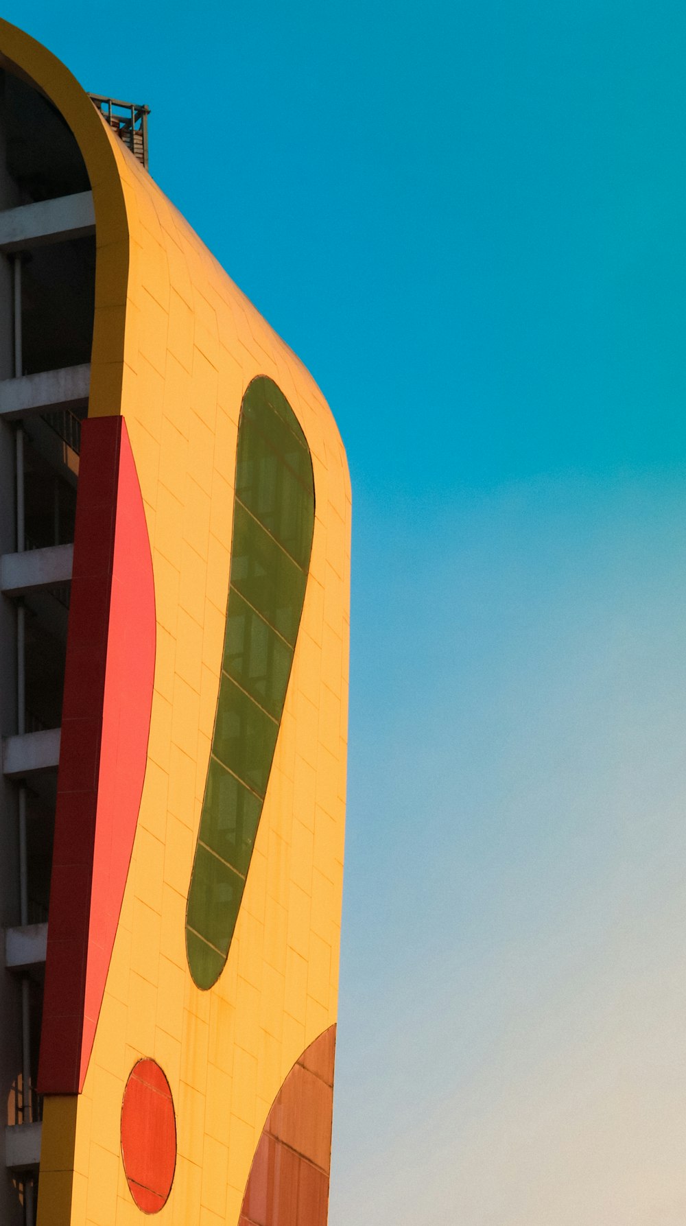 edificio in cemento rosso e bianco sotto il cielo blu durante il giorno