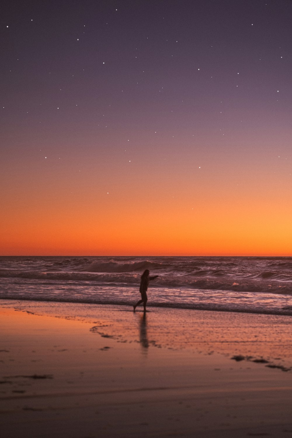pessoa em pé na praia durante o pôr do sol