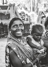 grayscale photo of woman carrying child