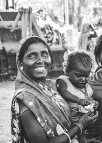 grayscale photo of woman carrying child