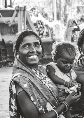 grayscale photo of woman carrying child