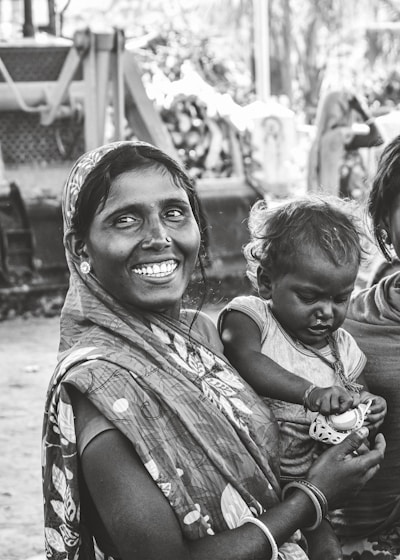 grayscale photo of woman carrying child