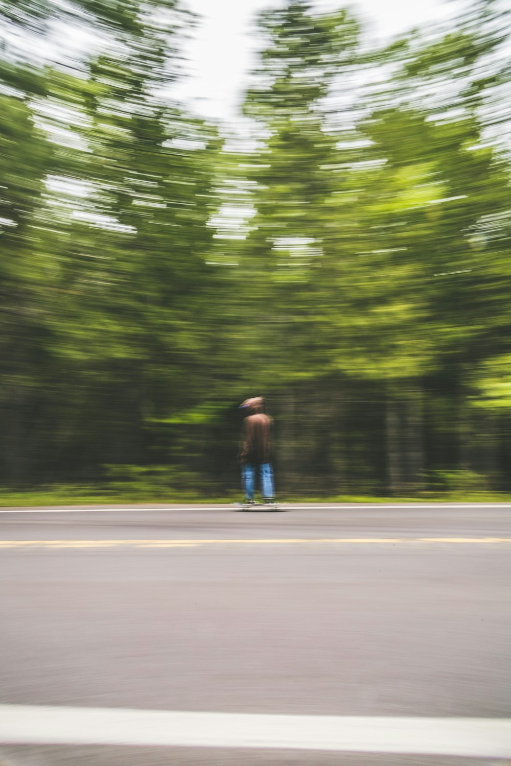 昼間に道を歩いている茶色のシャツと青いデニム ジーンズの男