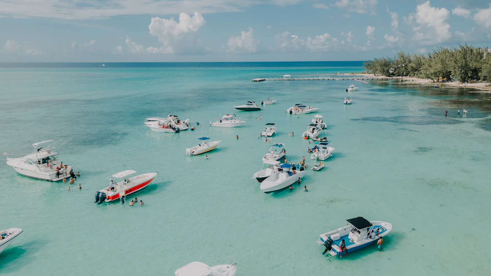 Aerial view of boats in turquoise water off the Cayman Islands