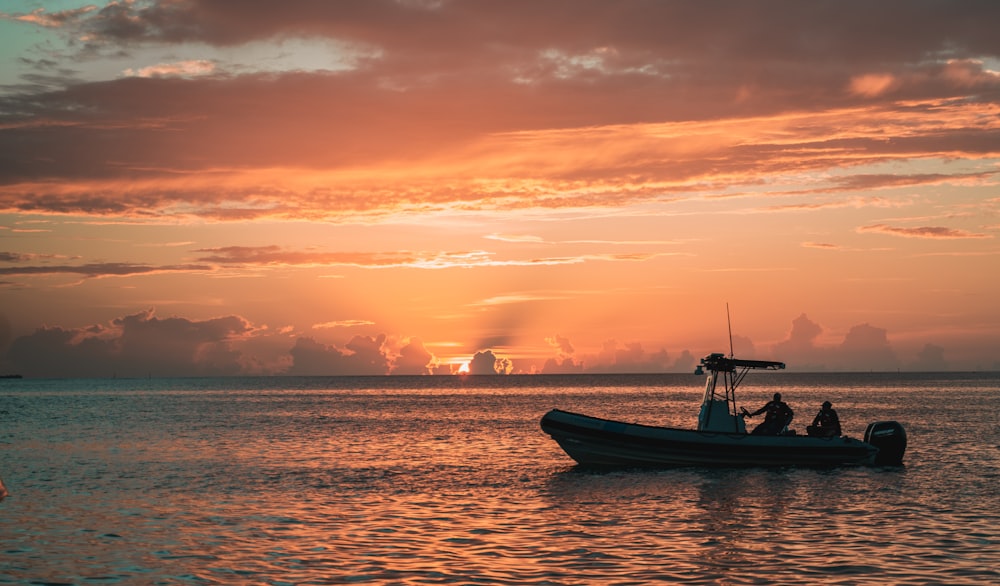 silhouette of boat on sea during sunset