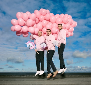 woman in pink jacket holding pink balloons