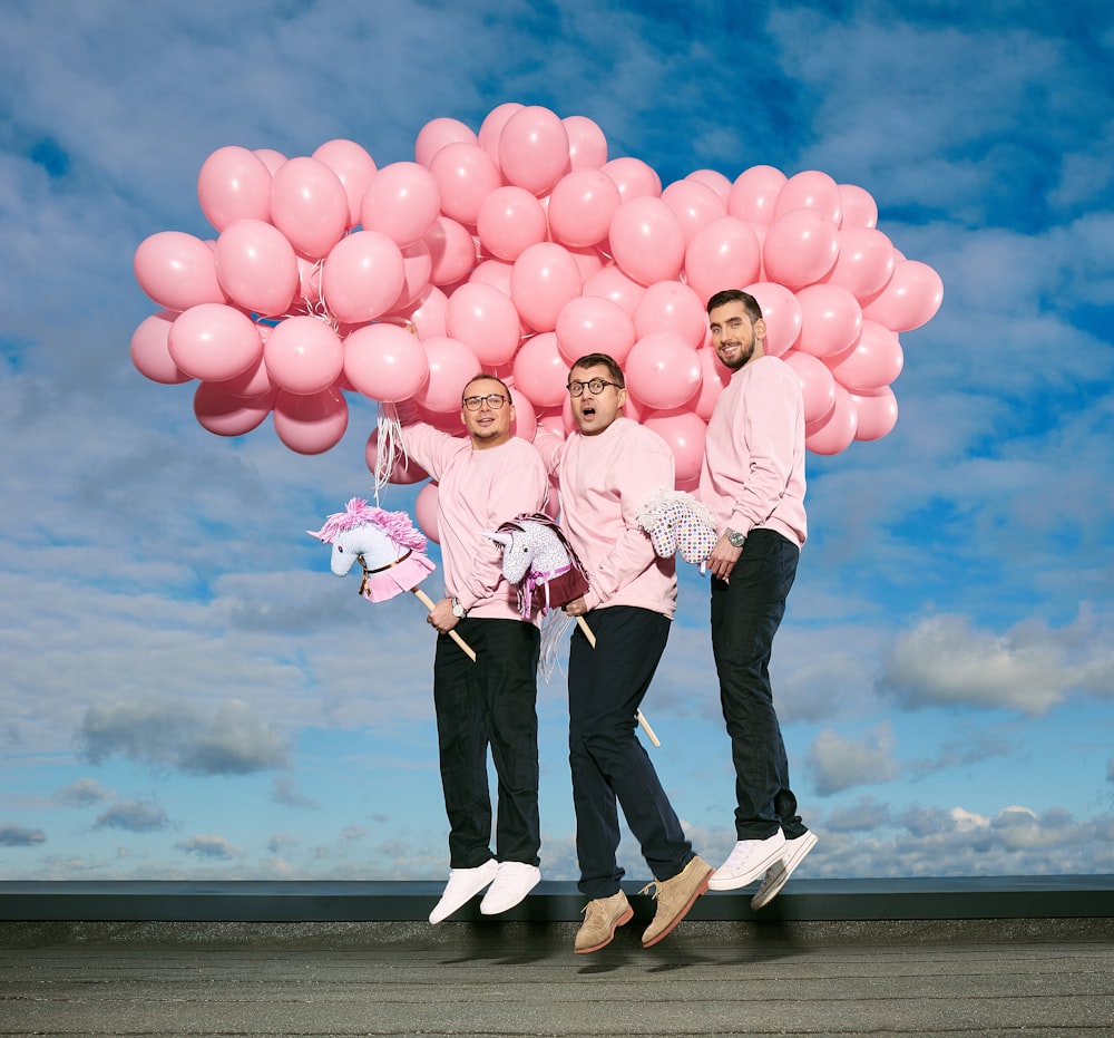 Femme en veste rose tenant des ballons roses