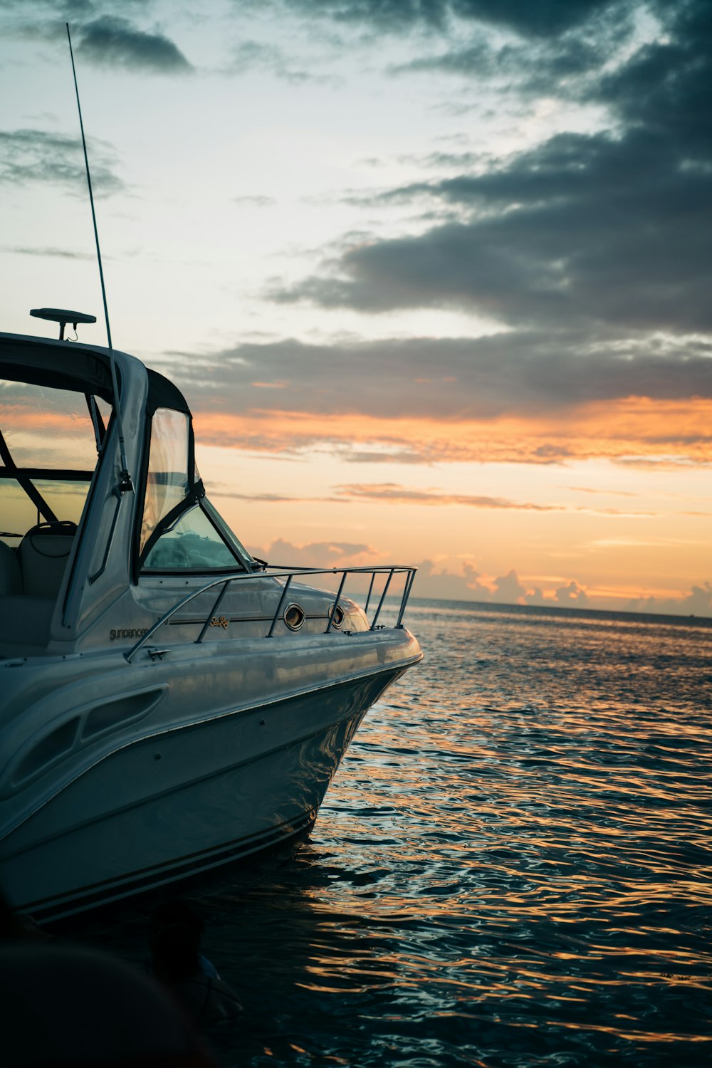 Bateau blanc et bleu sur la mer au coucher du soleil